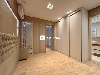Quarto com piso de madeira e armários embutidos na parede.