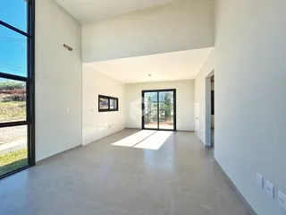 Ambiente interno amplo com paredes brancas e piso claro.