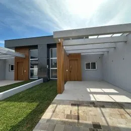 Área externa coberta com piso de concreto e gramado visível.