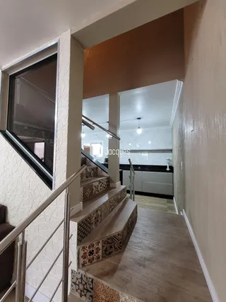 Vista de uma escadaria e área de transição em um imóvel residencial.