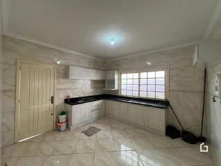 Imagem de uma cozinha com armários brancos e piso de cerâmica.