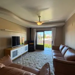 Foto da sala de estar mostrando um sofá e uma televisão.