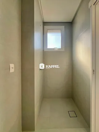 Foto de um corredor interno com paredes brancas e piso claro.