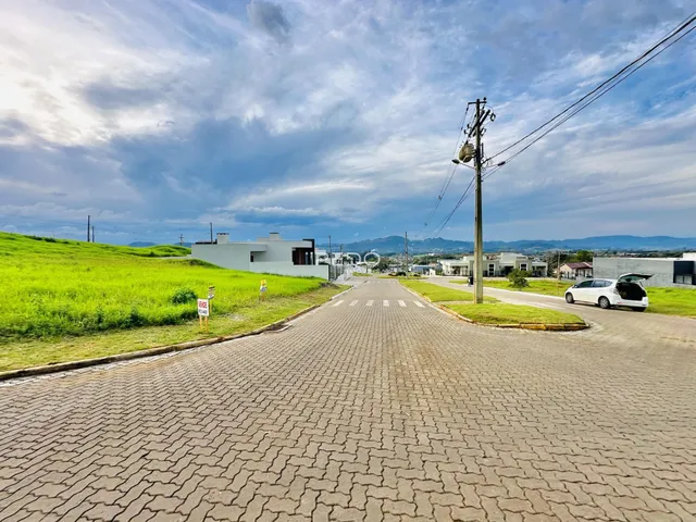 Vista externa de casas modernas em Lajeado, Brasil, com paisagem verde ao fundo.