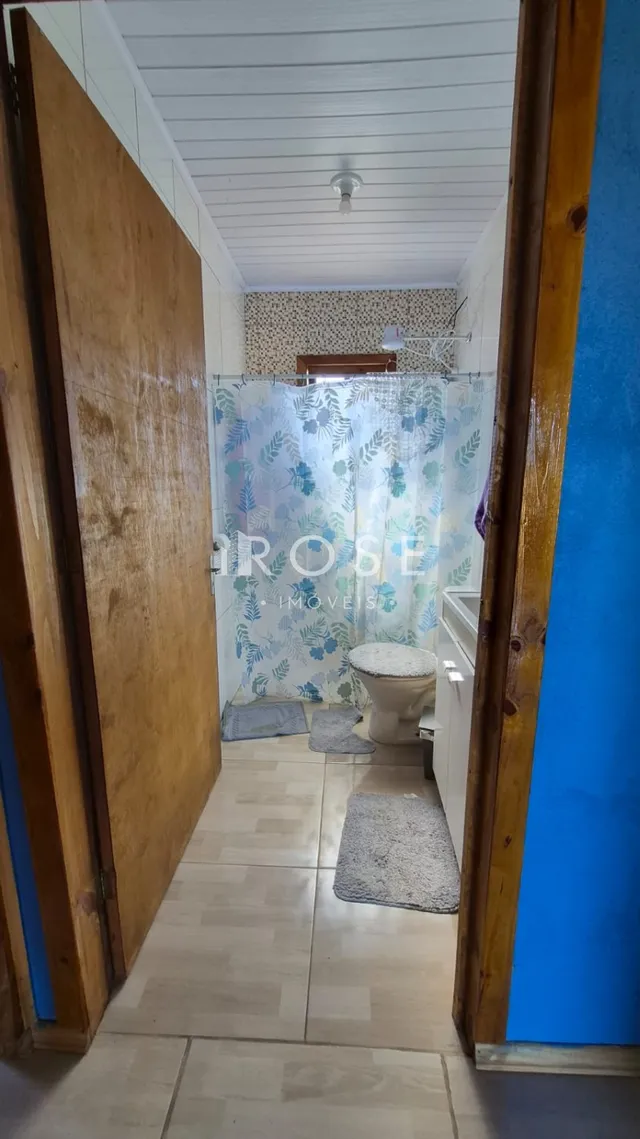 Corredor interno com piso claro e portas de madeira.