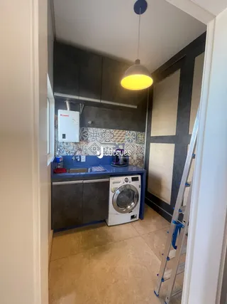Vista interna de uma cozinha com armários cinzas e piso claro.