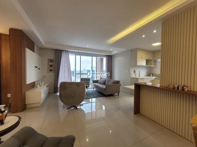 Sala de estar ampla com piso claro e iluminação moderna.