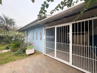 Fachada de uma casa em Lajeado, Brasil, com cerca e jardim na frente.