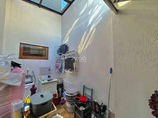 Interior de um cômodo com paredes brancas e teto inclinado.