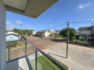 Vista da varanda com vista para uma rua e residências no entorno.