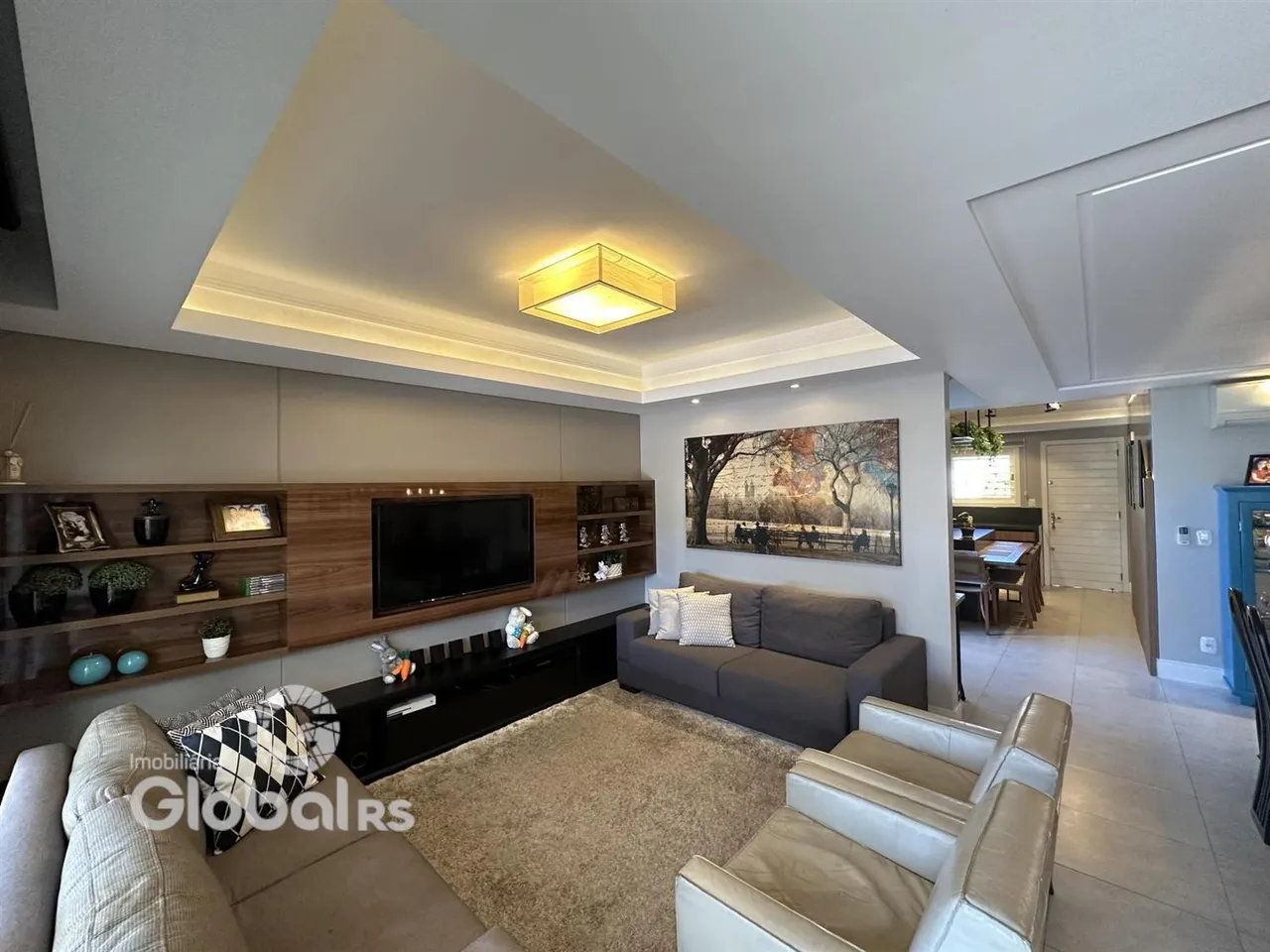 Sala de estar moderna com sofá e painel de madeira.