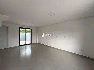 Sala de estar ampla com porta de vidro que dá acesso ao exterior.