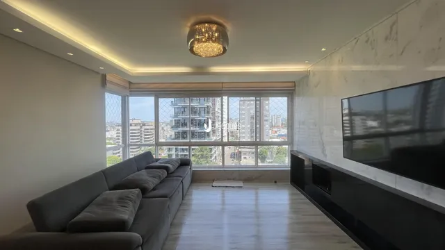Sala de estar moderna com piso de madeira e grande janela.