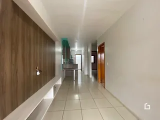 Corredor interno de um imóvel com piso de cerâmica e revestimento de madeira.