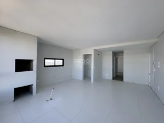 Sala de estar ampla com piso claro e paredes brancas.