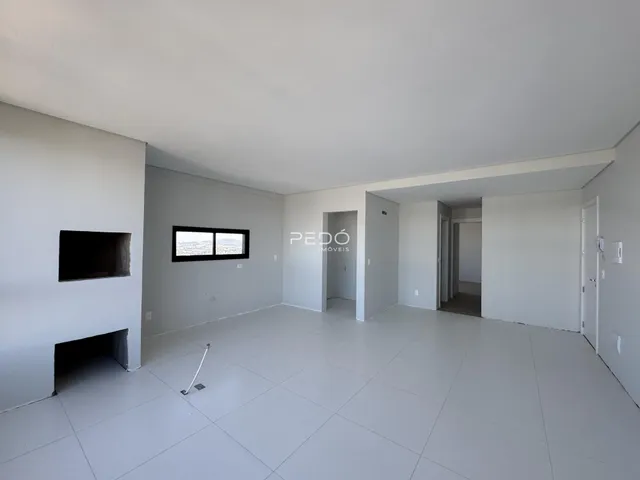 Sala de estar ampla com piso claro e paredes brancas.