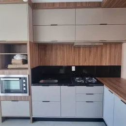 Foto de uma cozinha com armários de madeira e bancada escura.
