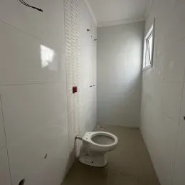 Hall de entrada com paredes brancas e painéis verticais.