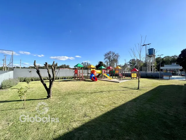 Vista externa de um gramado com área de lazer e playground.