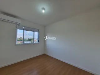 Sala de estar com piso de madeira e janela com vista para a cidade.