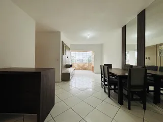 Ambiente interno de uma sala de jantar com piso de cerâmica clara.