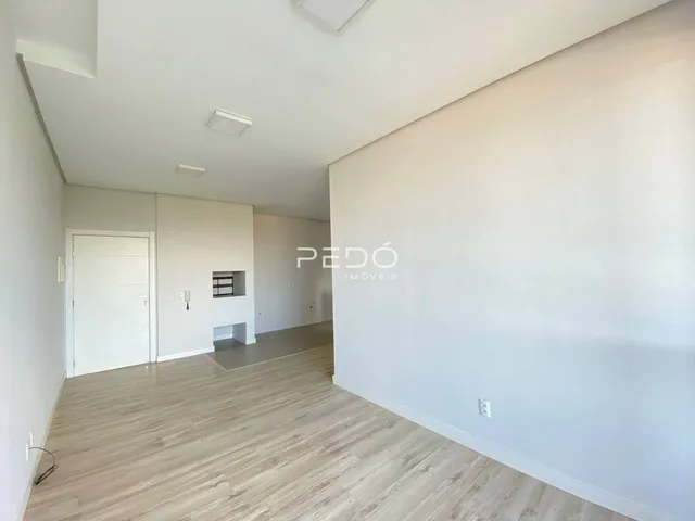 Hall com piso de madeira clara e paredes brancas.