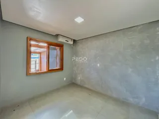 Ambiente interno de uma sala com janela de madeira e ar-condicionado.