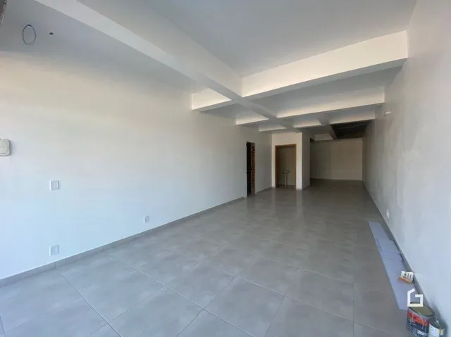Hall de corredor com paredes brancas e piso de cerâmica.