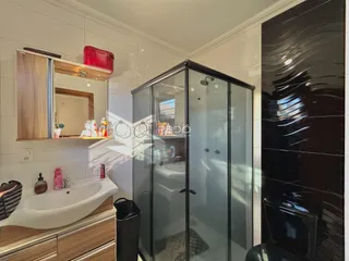 Banheiro com bancada e box de vidro em ambiente moderno.