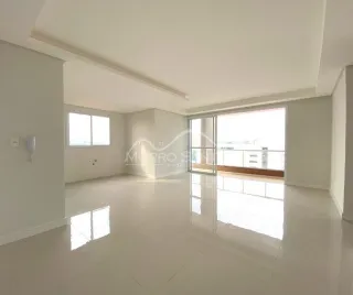 Ambiente interno amplo com piso claro e grandes janelas iluminando o espaço.