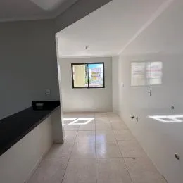 Foto de um corredor interno com piso de cerâmica e parede clara.