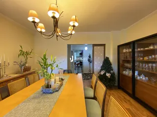 Uma sala de jantar com mesa de madeira e cadeiras.