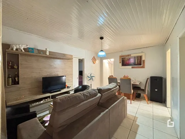 Foto da sala de estar com sofá e painel de madeira.