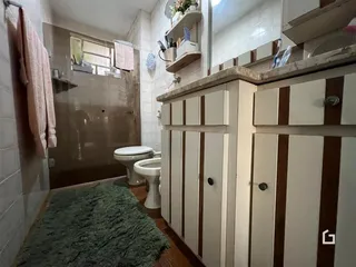 Foto de um banheiro com revestimento cerâmico e armários de madeira.