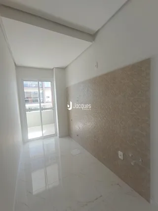 Hall de entrada com piso de mármore e porta de vidro.