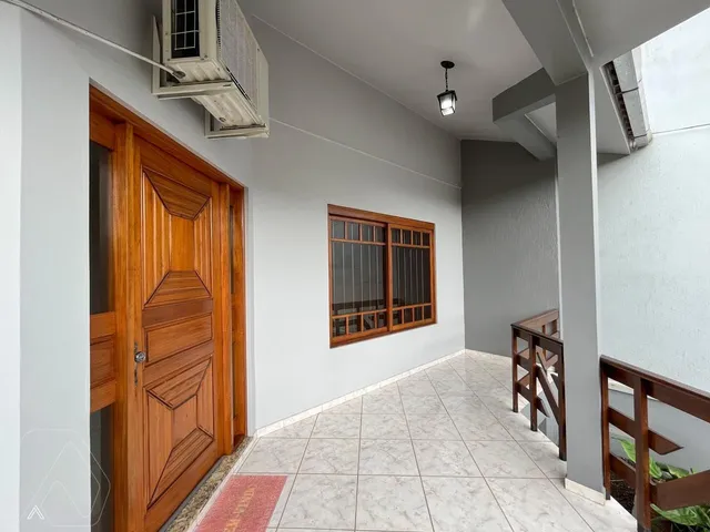 Foto de um corredor interno com piso de cerâmica e porta de madeira.
