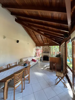 Sala de estar com piso de cerâmica e teto de madeira em uma residência.