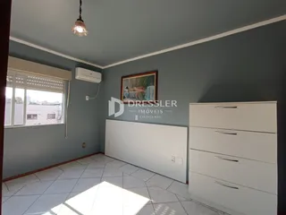 Vista interna de uma sala com janela e armário branco.