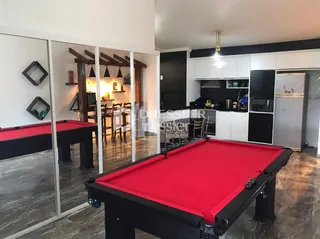 Imagem de um ambiente interno com paredes espelhadas e um objeto vermelho no primeiro plano.