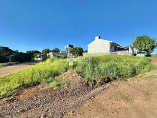 Fachada de uma casa em Lajeado, Brasil, com terreno gramado e vegetação alta.