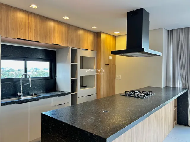 Cozinha moderna com armários de madeira e bancadas escuras.