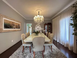 Uma sala de jantar com mesa e cadeiras em um ambiente claro.