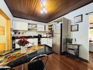 Uma cozinha aberta com armários brancos e piso de madeira.