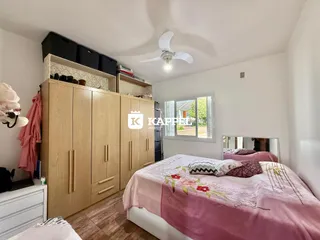Quarto com cama e armários de madeira em um ambiente claro.