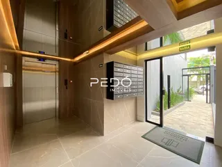 Hall de entrada com piso claro e detalhes em madeira.