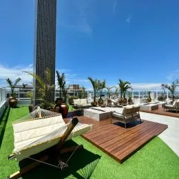 Varanda com espreguiçadeiras de madeira e deck com vista para o horizonte.