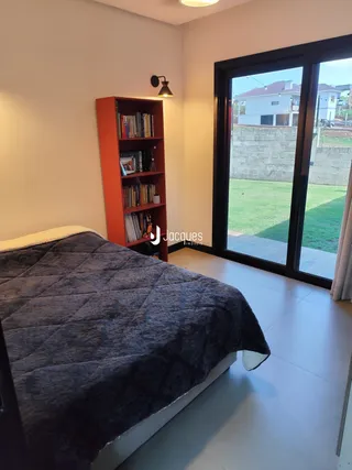 Quarto com cama e estante de livros em um apartamento.