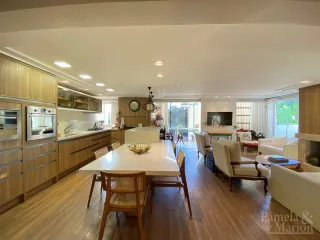 Ambiente interno com mesa de jantar de madeira e armários em um imóvel.