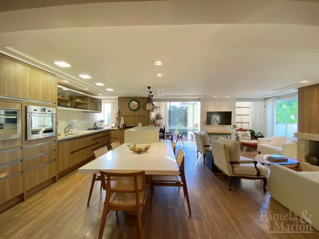 Ambiente interno com mesa de jantar de madeira e armários em um imóvel.