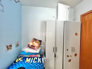 Quarto com armários brancos e decoração de parede.